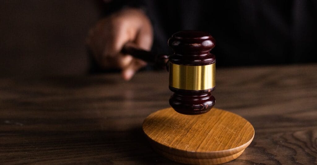 A gavel striking a sound block, symbolizing justice and legal authority in a courtroom setting.